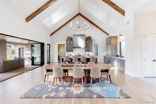 dining area featuring high vaulted ceiling, beamed ceiling, light hardwood / wood-style flooring, and a chandelier