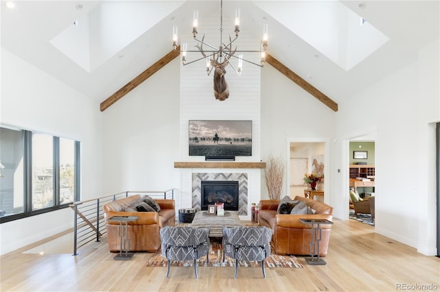 living room featuring a chandelier, high vaulted ceiling, light hardwood / wood-style floors, and a fireplace