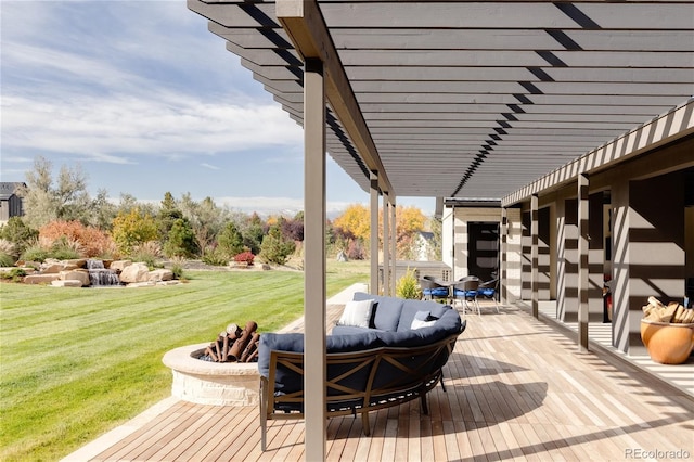 wooden terrace featuring a lawn and an outdoor living space with a fire pit