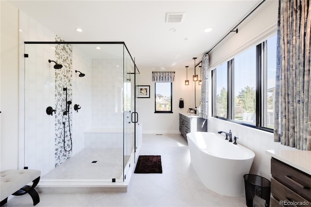 bathroom featuring tile patterned flooring, vanity, and shower with separate bathtub