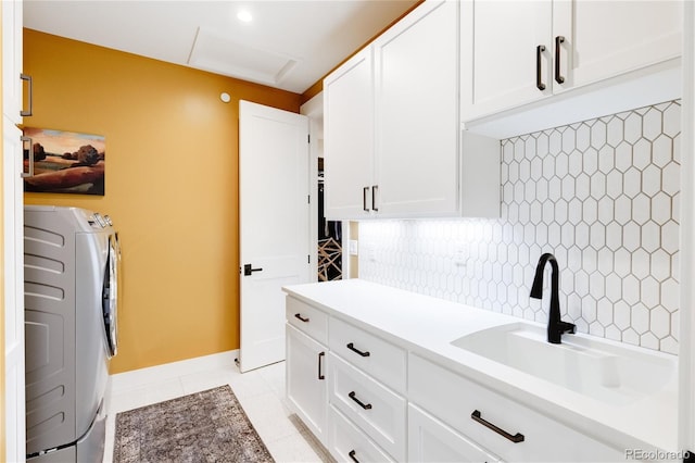 washroom featuring sink, cabinets, light tile patterned floors, and separate washer and dryer