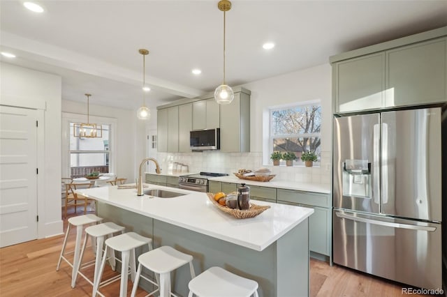 kitchen featuring pendant lighting, backsplash, appliances with stainless steel finishes, beamed ceiling, and sink