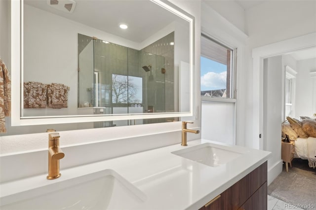 bathroom featuring a shower with door and vanity