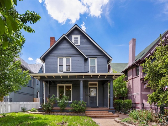 1423 Elizabeth St, Denver, CO 80206 - view of front of property with covered porch, fence, a chimney, and brick siding
