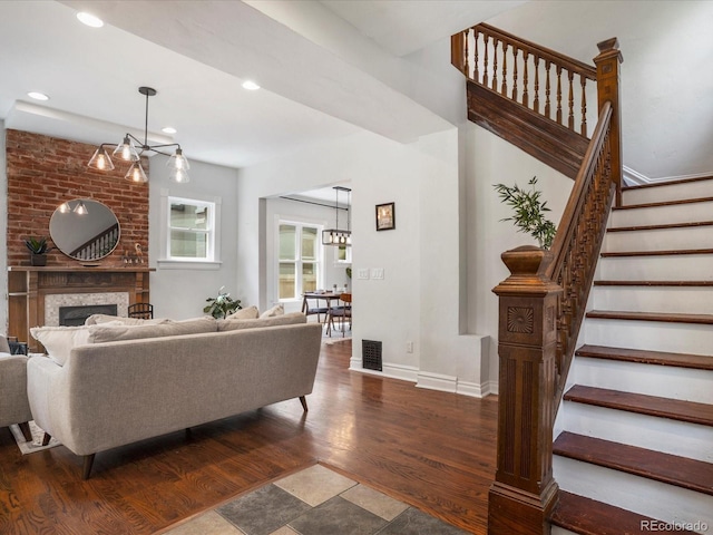 1423 Elizabeth St, Denver, CO 80206 - living room featuring a chandelier, stairway, dark wood-type flooring, a large fireplace, and baseboards