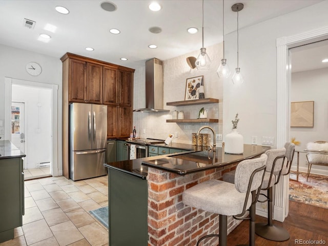 1423 Elizabeth St, Denver, CO 80206 - kitchen with stainless steel appliances, wall chimney exhaust hood, a peninsula, tasteful backsplash, and recessed lighting