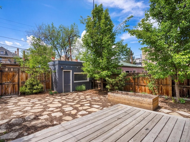 1423 Elizabeth St, Denver, CO 80206 - wooden terrace featuring fence, a vegetable garden, and an outbuilding