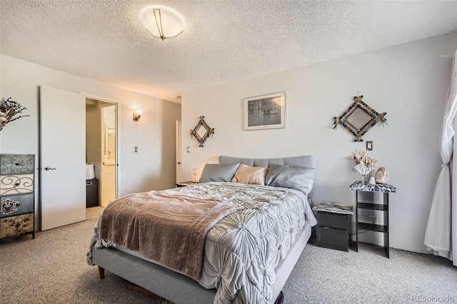 bedroom featuring connected bathroom, carpet, and a textured ceiling