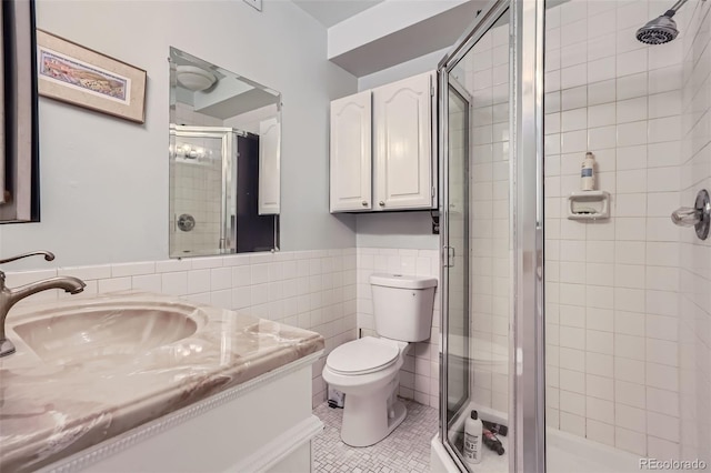 bathroom featuring vanity, toilet, and a shower with door