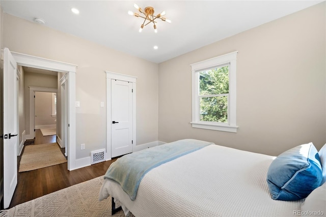 bedroom featuring dark wood-style flooring, baseboards, visible vents, recessed lighting, and a chandelier
