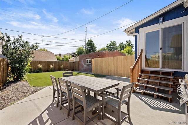 view of patio with a storage shed, outdoor dining space, a fenced backyard, an outdoor structure, and entry steps