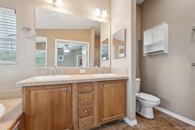 4481 Kingfisher Pt, Colorado Springs, CO 80922 - bathroom with double vanity, toilet, ceiling fan, tile patterned flooring, and a bathtub