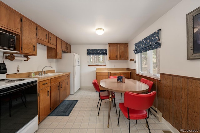 182 Colorado Dr, Tabernash, CO 80446 - kitchen with electric range oven, a sink, black microwave, a wainscoted wall, and brown cabinets