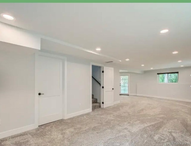 basement featuring carpet flooring, stairway, and baseboards