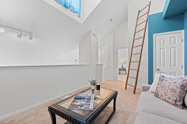 carpeted living room featuring rail lighting and vaulted ceiling