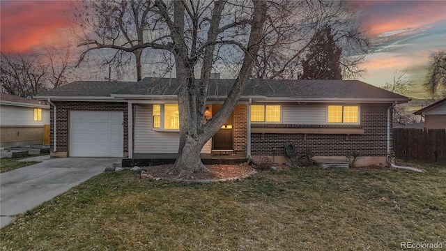 single story home featuring a garage and a yard