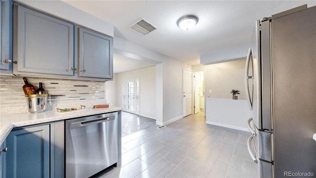 kitchen featuring tasteful backsplash, light stone countertops, french doors, and stainless steel appliances