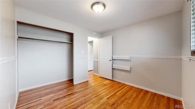 unfurnished bedroom featuring a closet and light wood-type flooring