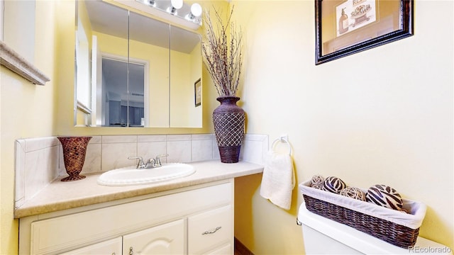 bathroom with backsplash, vanity, and toilet