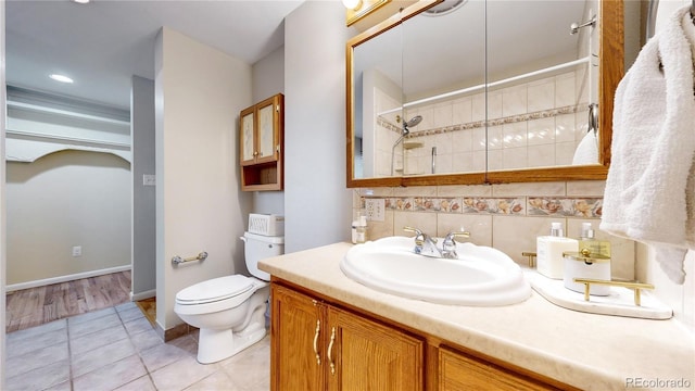 bathroom with vanity, tile patterned flooring, decorative backsplash, toilet, and walk in shower