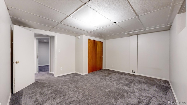 carpeted empty room featuring a paneled ceiling