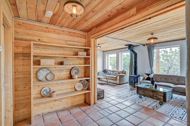28700 County Road 304, Buena Vista, CO 81211 - tiled living area featuring a wood stove, wood ceiling, and wooden walls