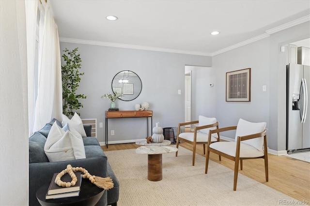 living room featuring baseboards, ornamental molding, recessed lighting, and light wood-style floors