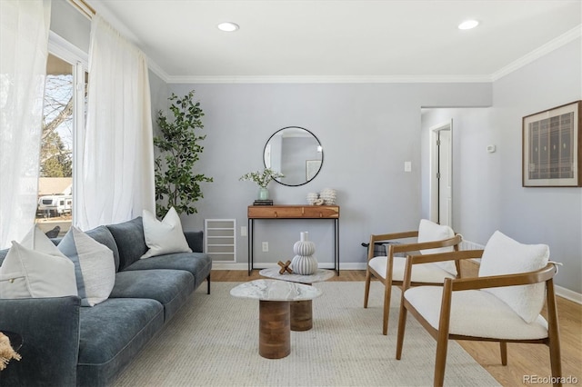 living area with light wood-style floors, visible vents, crown molding, and baseboards