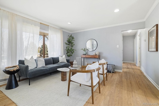 living area featuring baseboards, recessed lighting, light wood-style flooring, and crown molding