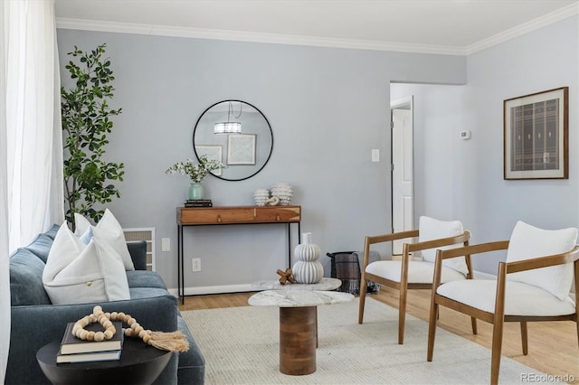 living area with ornamental molding, wood finished floors, and baseboards