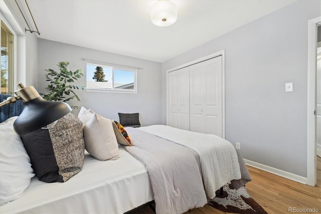 bedroom featuring a closet, baseboards, and wood finished floors