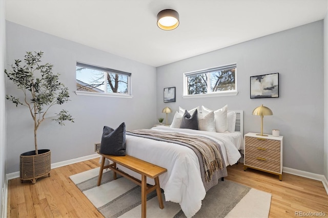 bedroom featuring baseboards and light wood finished floors