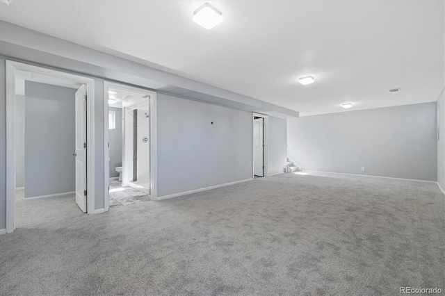 spare room featuring carpet floors, visible vents, and baseboards