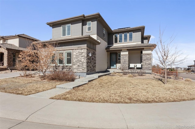 prairie-style house with stone siding and roof mounted solar panels