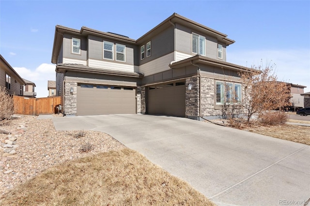 view of front facade with stone siding, fence, an attached garage, and concrete driveway