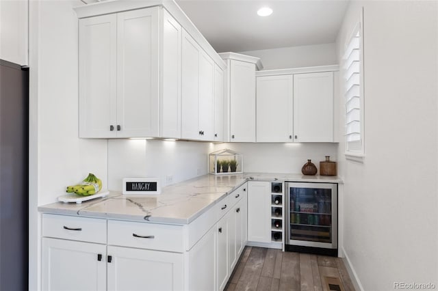 bar featuring beverage cooler, visible vents, baseboards, wood finished floors, and freestanding refrigerator