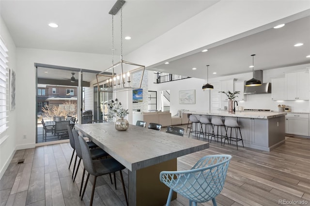 dining room with light wood-type flooring, a ceiling fan, and recessed lighting