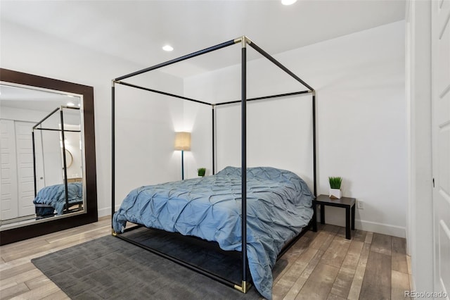 bedroom with baseboards, wood finished floors, and recessed lighting