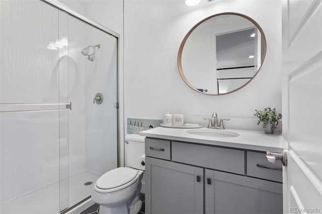 bathroom with a stall shower, vanity, and toilet