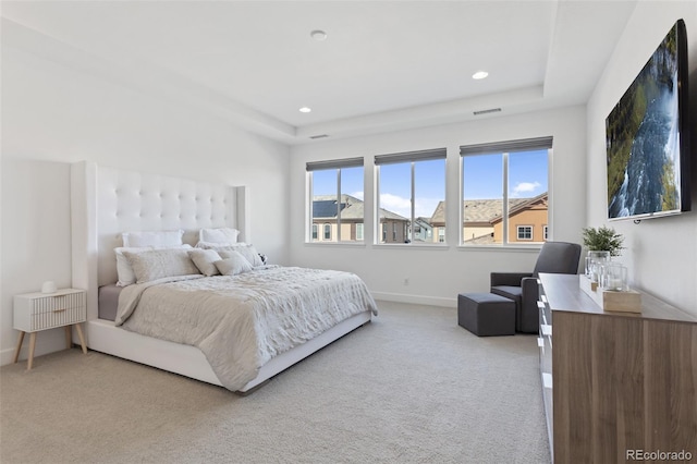 bedroom with recessed lighting, light carpet, visible vents, baseboards, and a tray ceiling