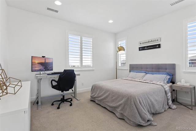 carpeted bedroom featuring multiple windows, visible vents, and recessed lighting