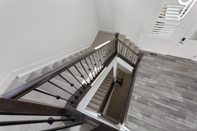 staircase featuring baseboards and wood finished floors