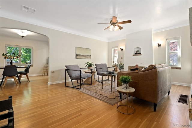 1434 Clermont St, Denver, CO 80220 - living area with arched walkways, ceiling fan, light wood-style flooring, and ornamental molding