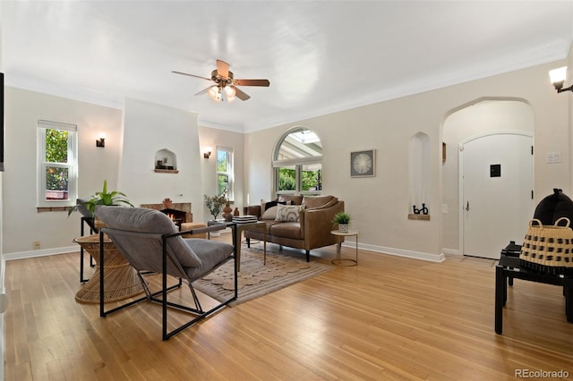 1434 Clermont St, Denver, CO 80220 - living area with ceiling fan, arched walkways, healthy amount of natural light, light wood finished floors, and crown molding