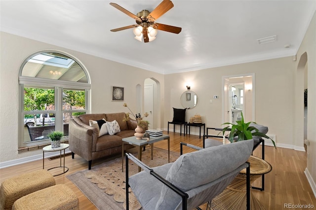 1434 Clermont St, Denver, CO 80220 - living area with arched walkways, a ceiling fan, light wood-style floors, and crown molding