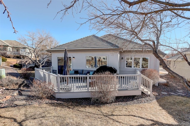 rear view of house with a tiled roof and a wooden deck