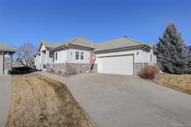 ranch-style home with a garage, stone siding, concrete driveway, a tiled roof, and stucco siding