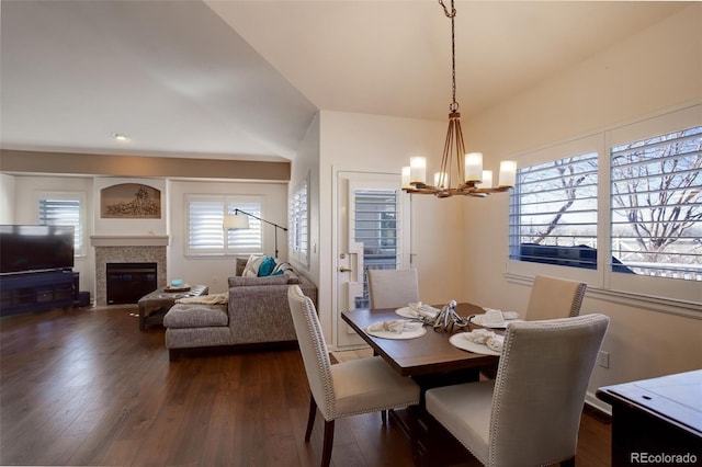 dining room featuring dark wood-style floors, a fireplace with flush hearth, and a chandelier