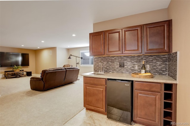 kitchen featuring dishwasher, decorative backsplash, a sink, and light colored carpet