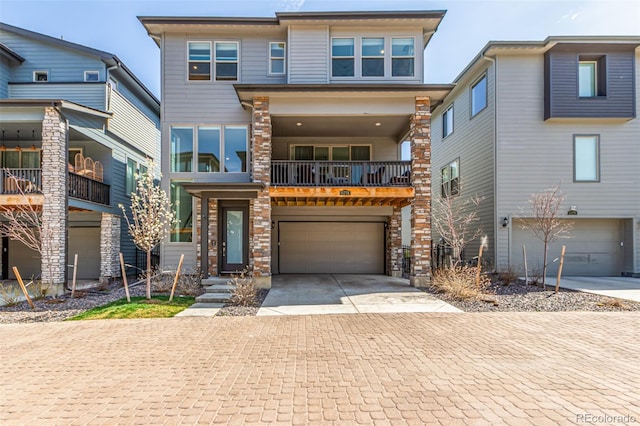 15774 W Girard Ave, Morrison, CO 80465 - view of front of house with stone siding, decorative driveway, and an attached garage